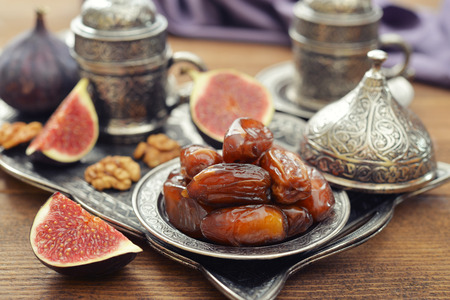 Cup of coffee with dry dates on metal oriental trayの写真素材