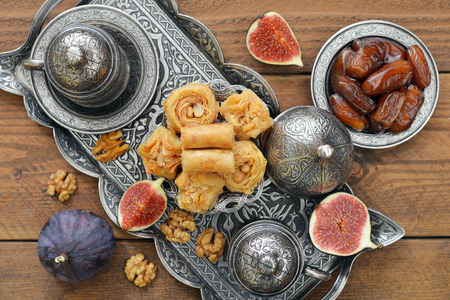 Cup of coffee with baklava and metal oriental tray on wooden backgroundの写真素材