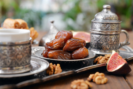 Dry dates with cups of coffee on metal oriental trayの写真素材