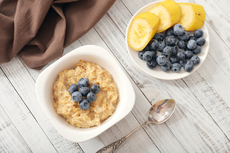 Bowl of oatmeal porridge with bananas and blueberry. Top view.の写真素材