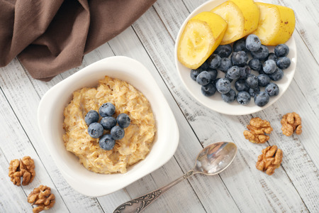 Bowl of oatmeal porridge with bananas and blueberry. Top view.の写真素材
