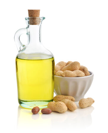 Peanut oil with raw peanuts isolated on white backgroundの写真素材