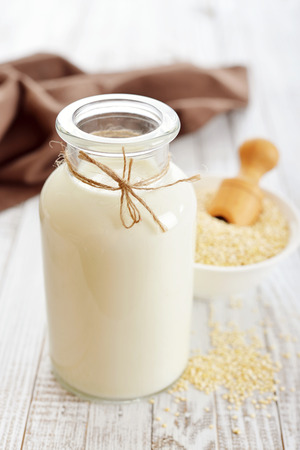 Quinoa milk in glass bottle on wooden backgroundの写真素材