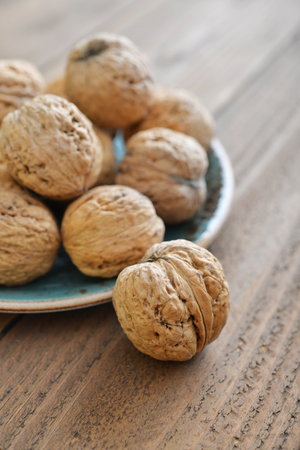 Whole walnuts on rustic old wooden background closeupの写真素材