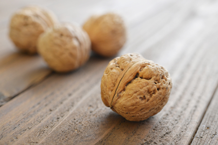 Whole walnuts on rustic old wooden background closeupの写真素材