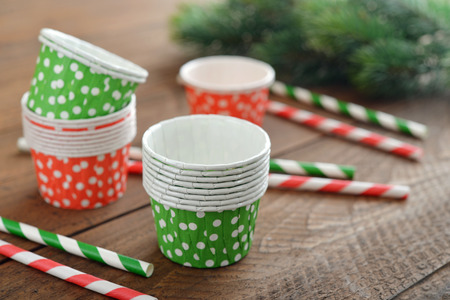 Cupcake cases with striped drink straws on wooden backgroundの写真素材