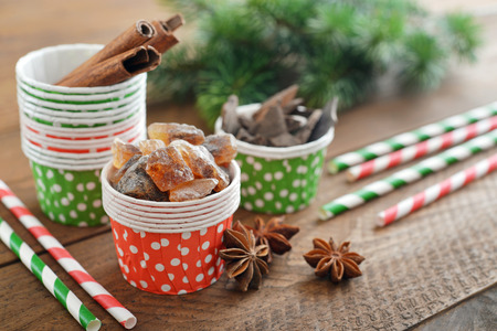 Sugar, cinnamon sticks and chocolate in cupcake cases on wooden backgroundの写真素材