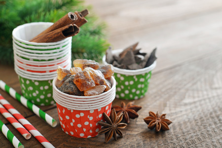Sugar, cinnamon sticks and chocolate in cupcake cases on wooden backgroundの写真素材
