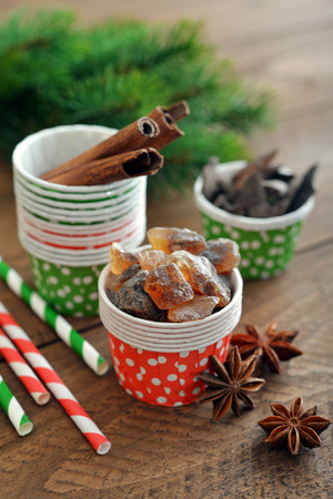 Sugar, cinnamon sticks and chocolate in cupcake cases on wooden backgroundの写真素材