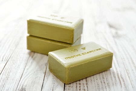 Greek olive soap on wooden background closeup. The words on soap translates as best qualityの写真素材