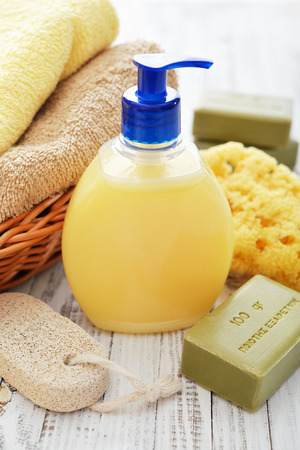 Greek olive soap with shower gel and bath towels on wooden backgroundの写真素材