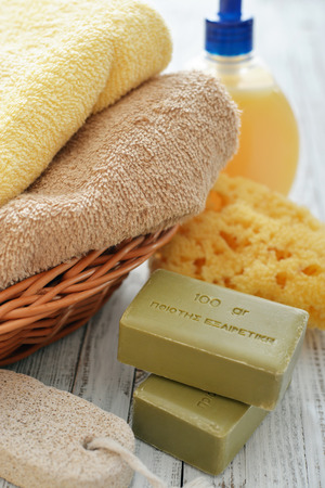Greek olive soap with shower gel and bath towels on wooden backgroundの写真素材