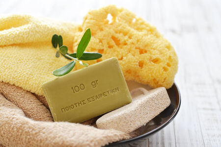 Greek olive soap with bath towels and bath sponge in bowl closeupの写真素材