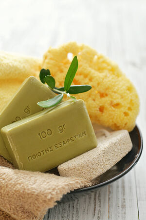 Greek olive soap with bath towels and bath sponge in bowl closeupの写真素材