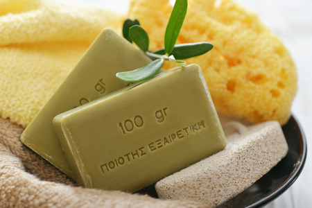 Greek olive soap with bath towels and bath sponge in bowl closeupの写真素材