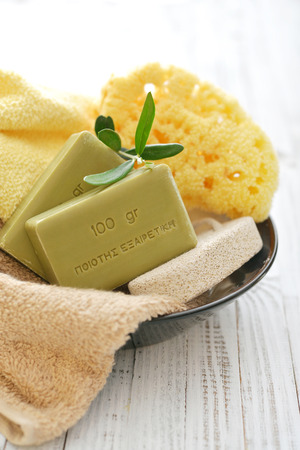 Greek olive soap with bath towels and bath sponge in bowl closeupの写真素材