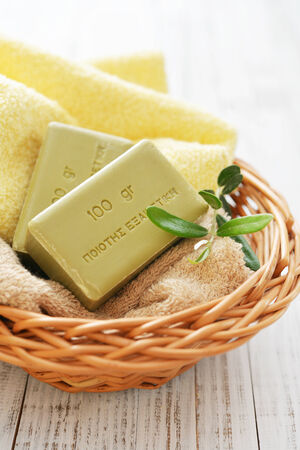 Greek olive soap with bath towels and olive twig in basket closeupの写真素材