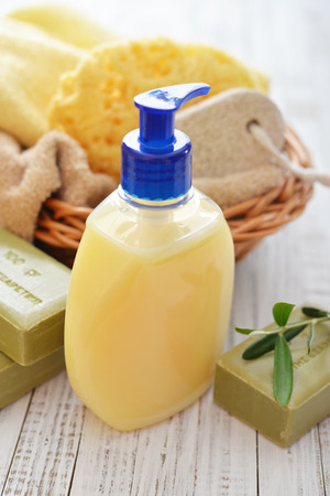 Shower gel with  olive soap and bath towels on wooden backgroundの写真素材