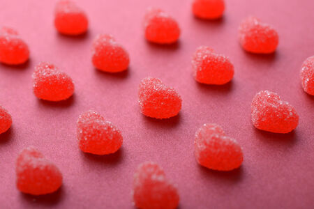 Candy in shape of hearts on red background.の写真素材
