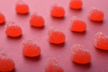 Candy in shape of hearts on red background.の写真素材