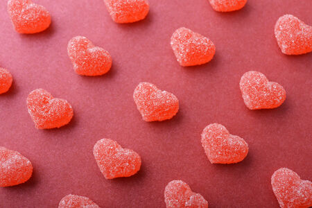 Candy in shape of hearts on red background.の写真素材