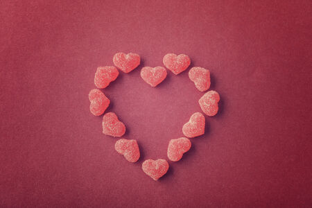 Candy in shape of hearts on red background. Top view.の写真素材