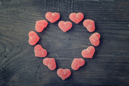 Candy in shape of hearts on wooden background. Top view.の写真素材