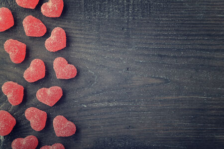 Candy in shape of hearts on wooden background. Top view.の写真素材