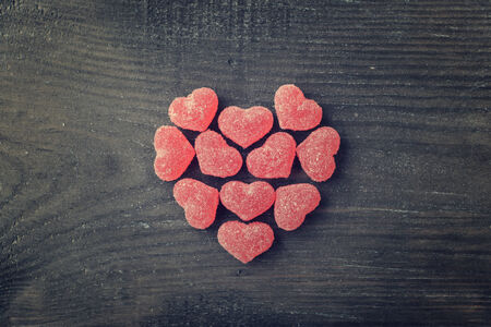 Candy in shape of hearts on wooden background. Top view.の写真素材