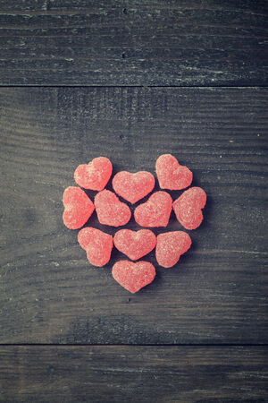 Candy in shape of hearts on wooden background. Top view.の写真素材