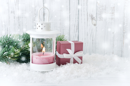 Christmas decorations with candle in lantern and gift box on wooden backgroundの写真素材