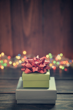Stack of gift boxes with red bow over wooden backgroundの写真素材