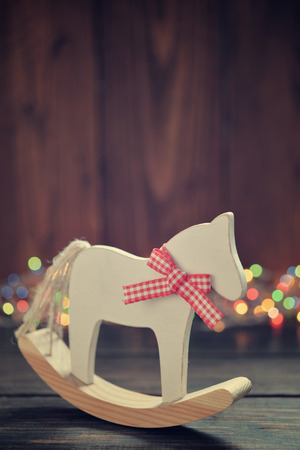 Toy horse with christmas lights on wooden backgroundの写真素材