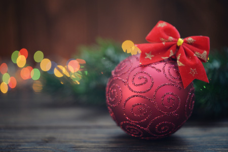 Red christmas decorative ball with fir tree branch on wooden backgroundの写真素材