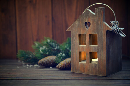 Christmas lantern in shape of small wooden house with candle insideの写真素材