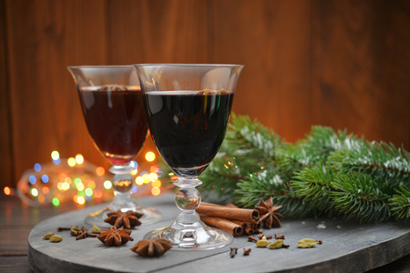 Mulled wine with spices and christmas decoration on wooden backgroundの写真素材