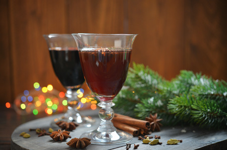 Mulled wine with spices and christmas decoration on wooden backgroundの写真素材