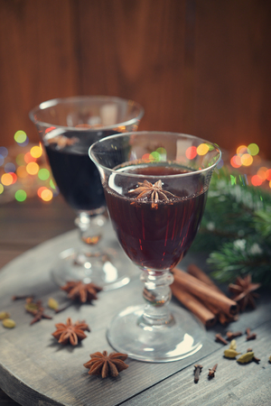 Mulled wine with spices and christmas decoration on wooden backgroundの写真素材