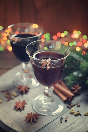 Mulled wine with spices and christmas decoration on wooden backgroundの写真素材