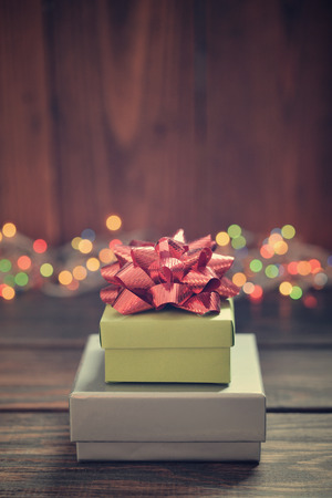 Stack of gift boxes with red bow over wooden backgroundの写真素材