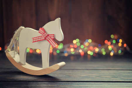 Toy horse with christmas lights on wooden backgroundの写真素材