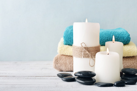 Candles with towels on light blue backgroundの写真素材