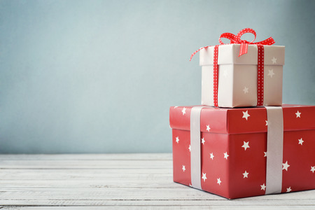 Gift boxes with ribbons and christmas decor on wooden background