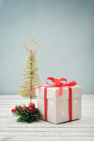 Gift box with ribbon and christmas decor on wooden backgroundの写真素材