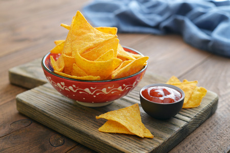 Corn nachos in bowl with sauce on wooden backgroundの写真素材