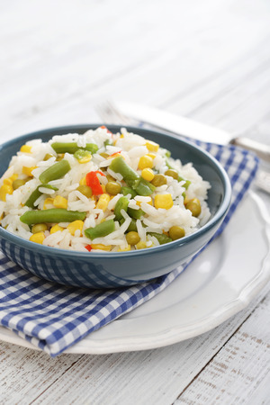Vegetable risotto on plate with fork and knife on wooden backgroundの写真素材
