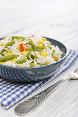 Vegetable risotto on plate with fork on wooden backgroundの写真素材