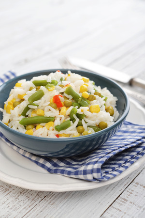 Vegetable risotto on plate with fork and knife on wooden backgroundの写真素材