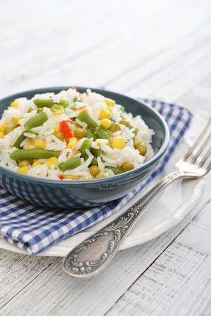 Vegetable risotto on plate with fork on wooden backgroundの写真素材