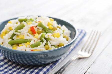 Vegetable risotto on plate with fork on wooden backgroundの写真素材